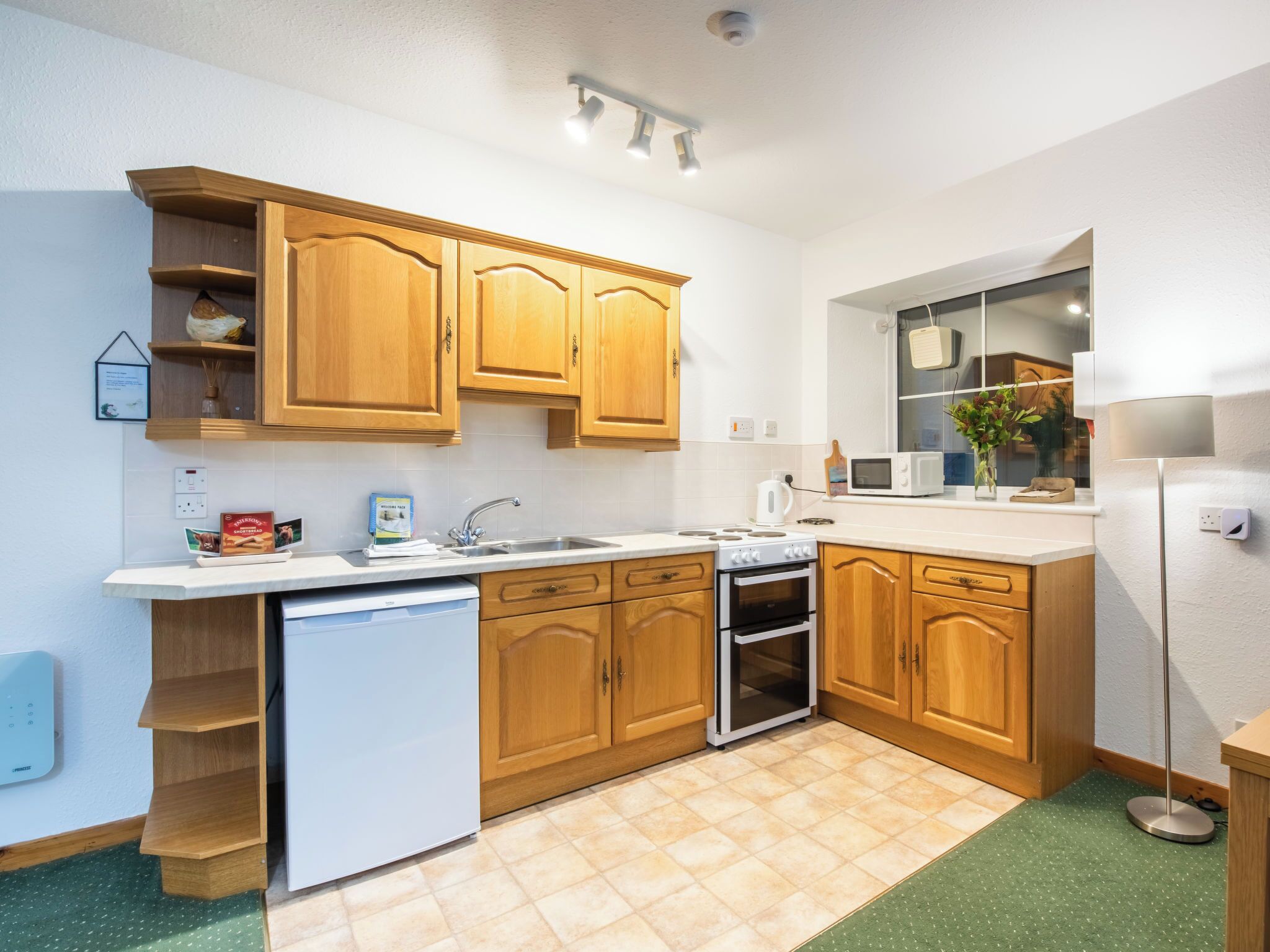Une cuisine moderne avec des meubles en bois, un lave-vaisselle encastré, un four à micro-ondes et une cuisinière.