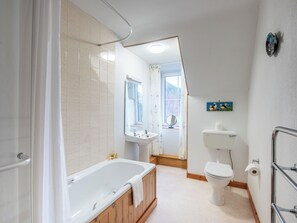 Ett modernt badrum med badkar, toalett och handfat.
