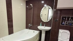A modern bathroom with a bathtub, sink, and toilet.