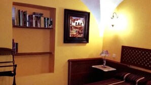 A bedroom with a bed, a nightstand, a lamp, a bookshelf, and a framed picture on the wall. - Tictágora House: House 1 (Plasenzuela)