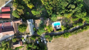 Vista aérea de um espaço com vários edifícios, piscina e carros estacionados.