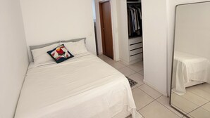Ein Schlafzimmer mit einem Bett, einem Kleiderschrank und einem Spiegel.