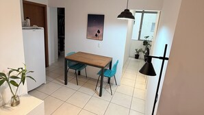 Eine moderne Küche mit Holztisch und -stühlen, einer hängenden Pendelleuchte und einem Gemälde des Nachthimmels.