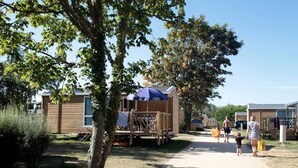 Un camping con casas móviles, una zona de estar cubierta y un sendero.