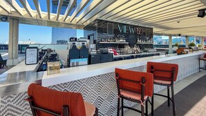 A rooftop bar with a modern design, featuring a bar counter, seating area, and a view of the city skyline. - PVH - Seven Palm - Studio Beach Access (Dubai)