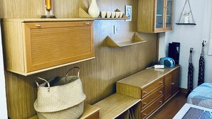 A room with wooden panel walls, built-in shelves, a bed with a patterned bedspread, and a small table with a white object on it. - Casona Mayor (pets allowed) (Andorra)