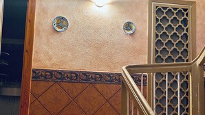 A staircase with a wooden handrail and a decorative wall with a geometric pattern. - Casona Mayor (pets allowed) (Andorra)
