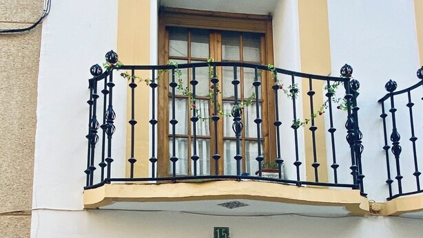 A building with a stone facade, a wooden door, and a balcony with black railings. - Casona Mayor (pets allowed) (Andorra)