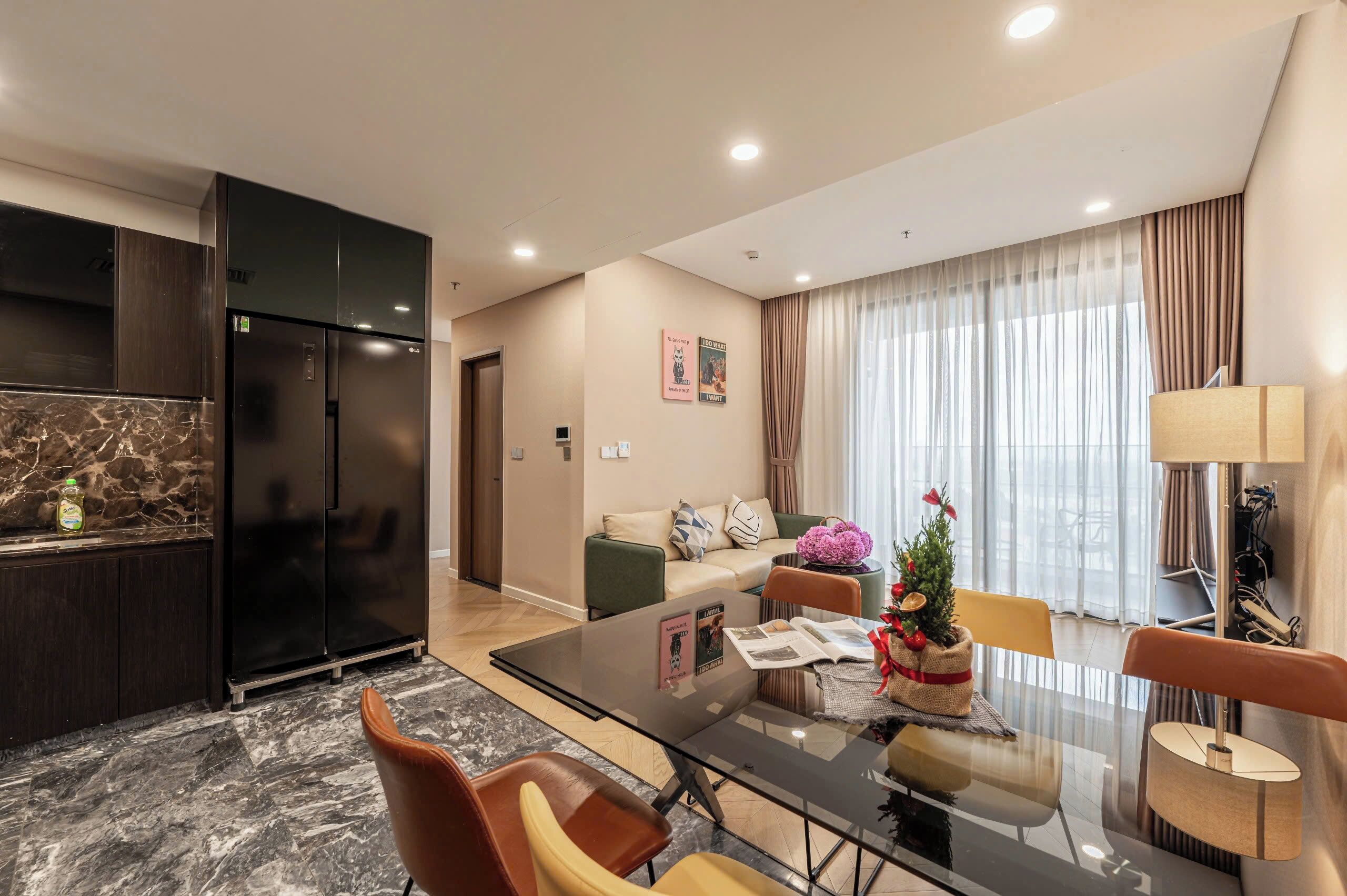 Una sala de estar moderna con una mesa de centro de vidrio, sillas de cuero, un sofá y una zona de comedor con una mesa de vidrio.