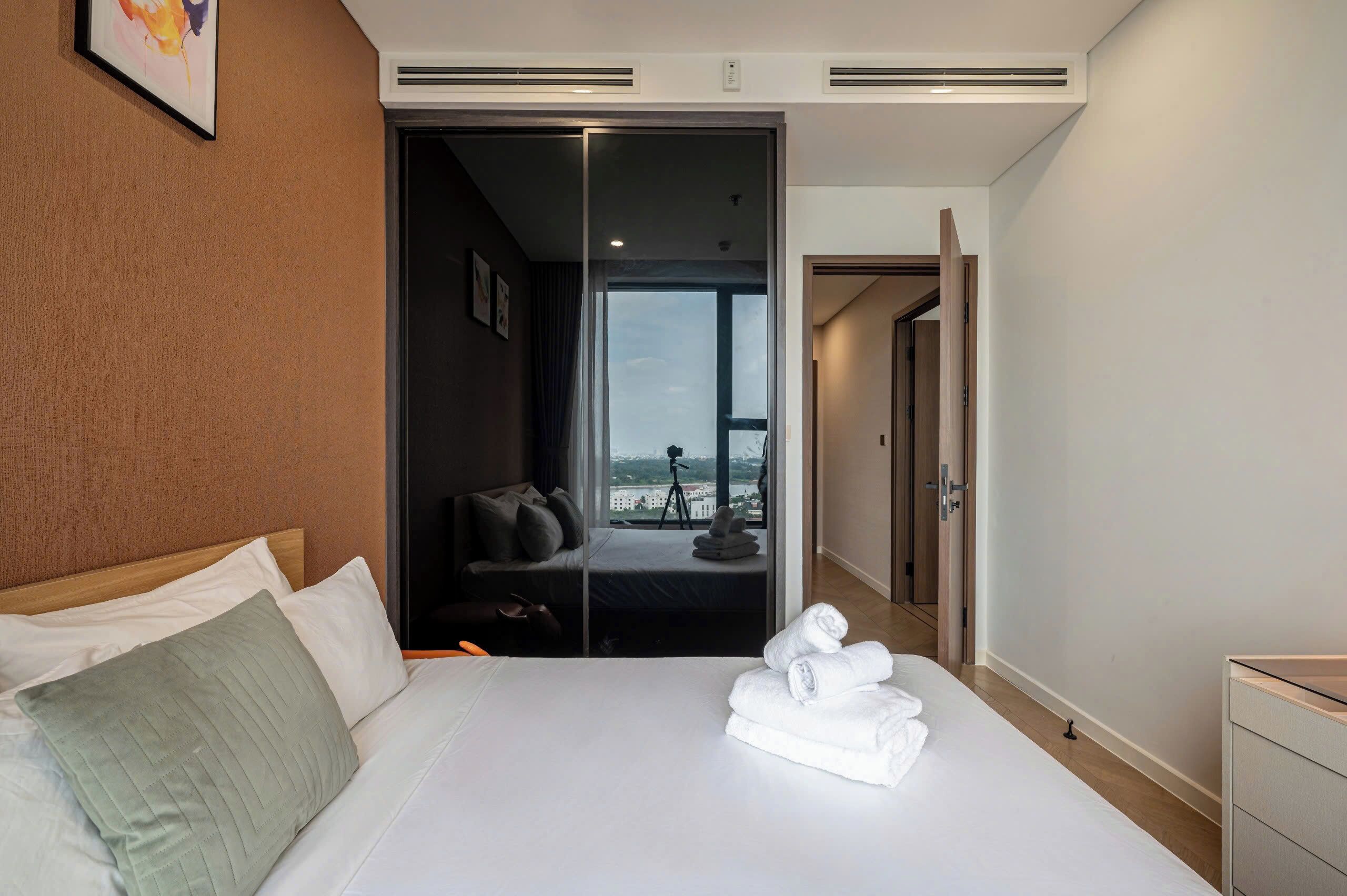 Quarto de hotel com uma cama, área de estar com vista e porta para uma varanda.