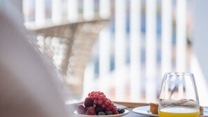 A breakfast setting with a plate of berries and a glass of orange juice. - Modern, tastefully furnished hotel room of approximately 28 square meters, featuring a double bed and a single bed, a bathroom with a bathtub or shower, and a large balcony furnished with a table and chairs.Use of the pool and gymUnlimited access to the  (Olbia)