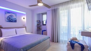 A modern bedroom with a bed, a ceiling fan, a TV, and a view of the outdoors. - Marthina Luxury Living (Nea Propontida)