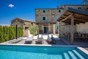 A stone building with a pool, lounge chairs, and a table with fruit. - Casa Chiara, Your Holiday Home with pool in Motovun, Istria (Motovun)