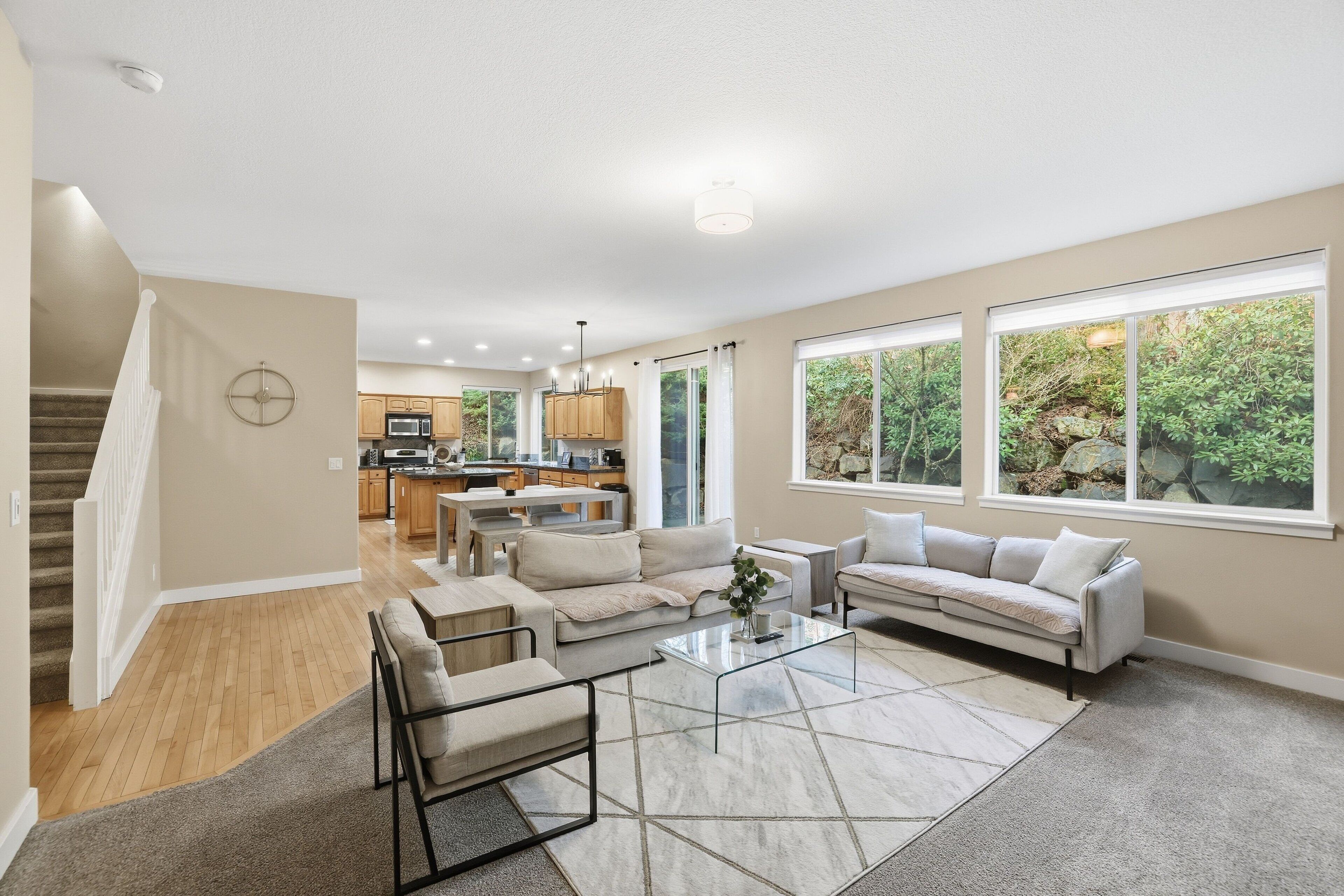 A spacious living area with a sofa, coffee table, and a view of the kitchen.