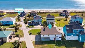 A coastal residential area with houses, a clear view of the beach, and a marked beach access point. - Casa Bella 4 Bedroom Home (Port Bolivar)