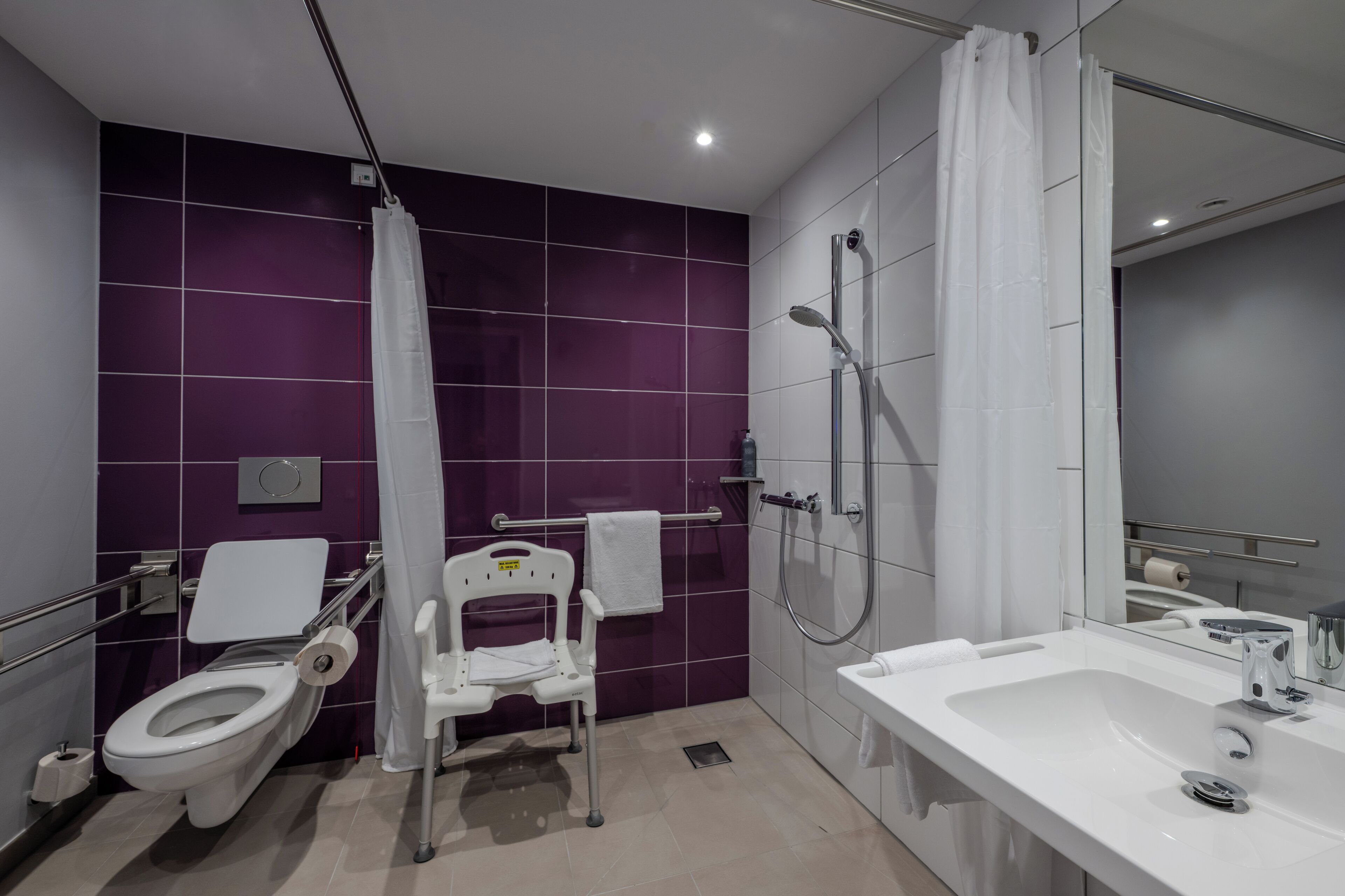 A modern bathroom with a toilet, shower, and sink.