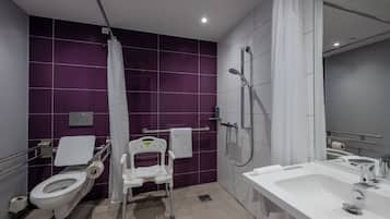 A modern bathroom with a toilet, shower, and sink.