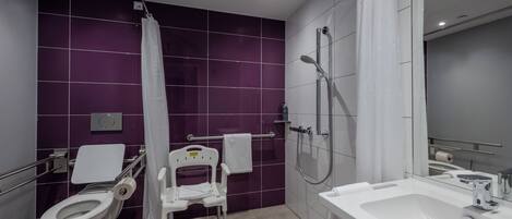 A modern bathroom with a toilet, shower, and sink.
