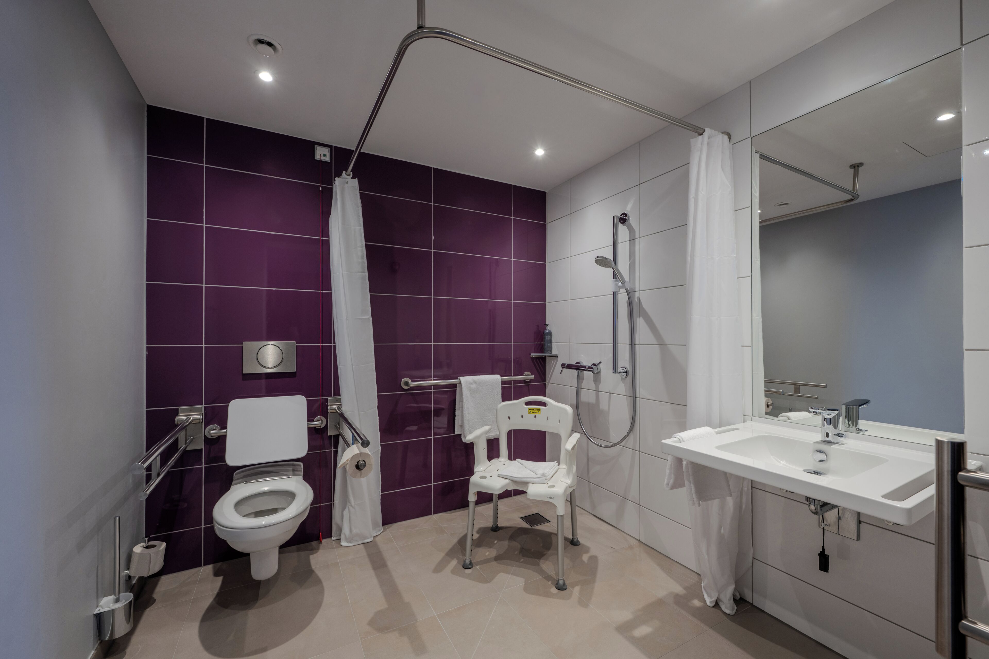 A modern bathroom with a toilet, shower, and sink.