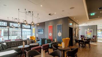 A modern lounge area with seating, tables, and artwork on the walls.