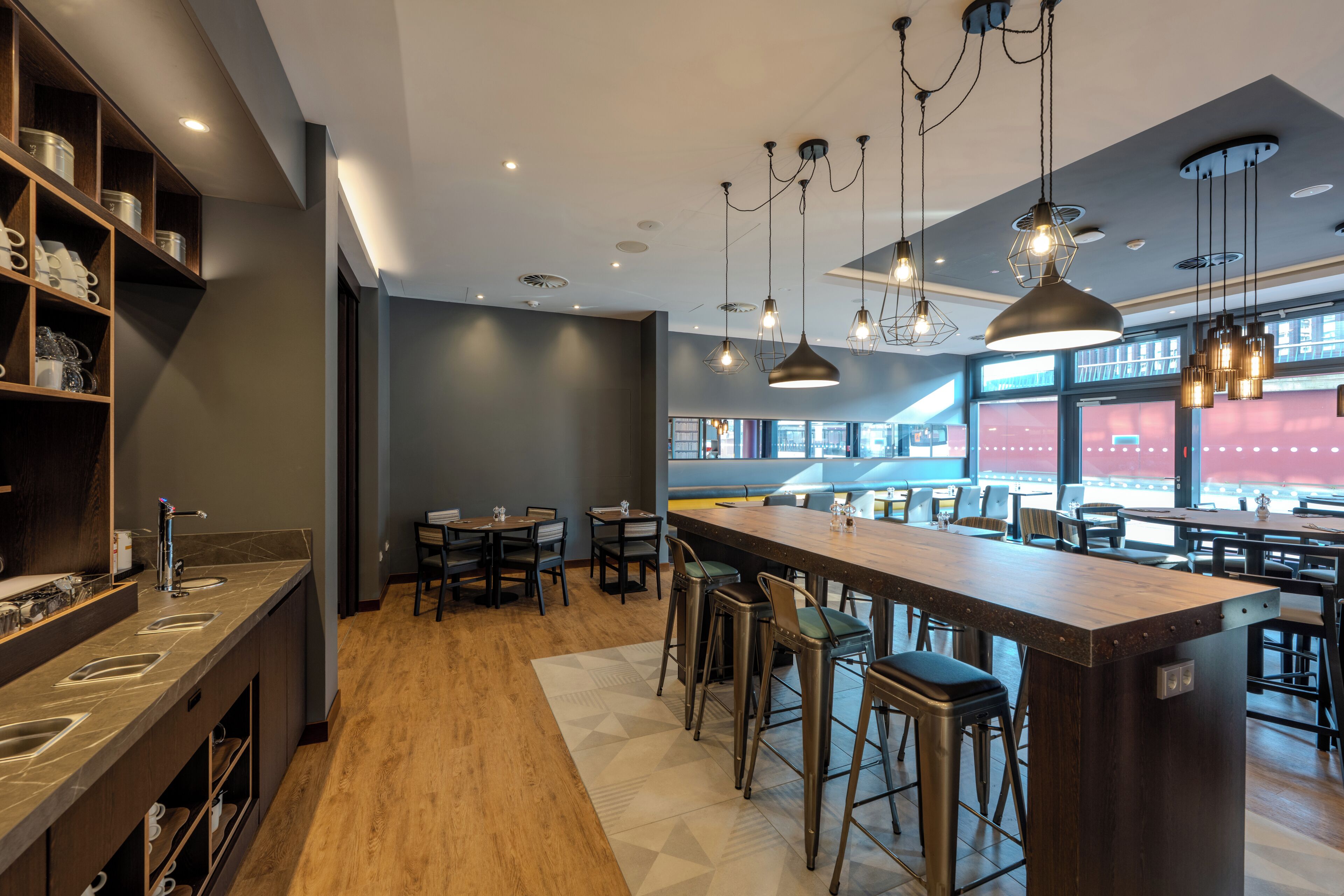 Una cocina moderna con una isla central, taburetes de bar e iluminación colgante.