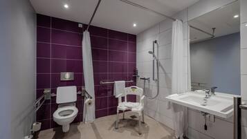A modern bathroom with a toilet, shower, and sink.