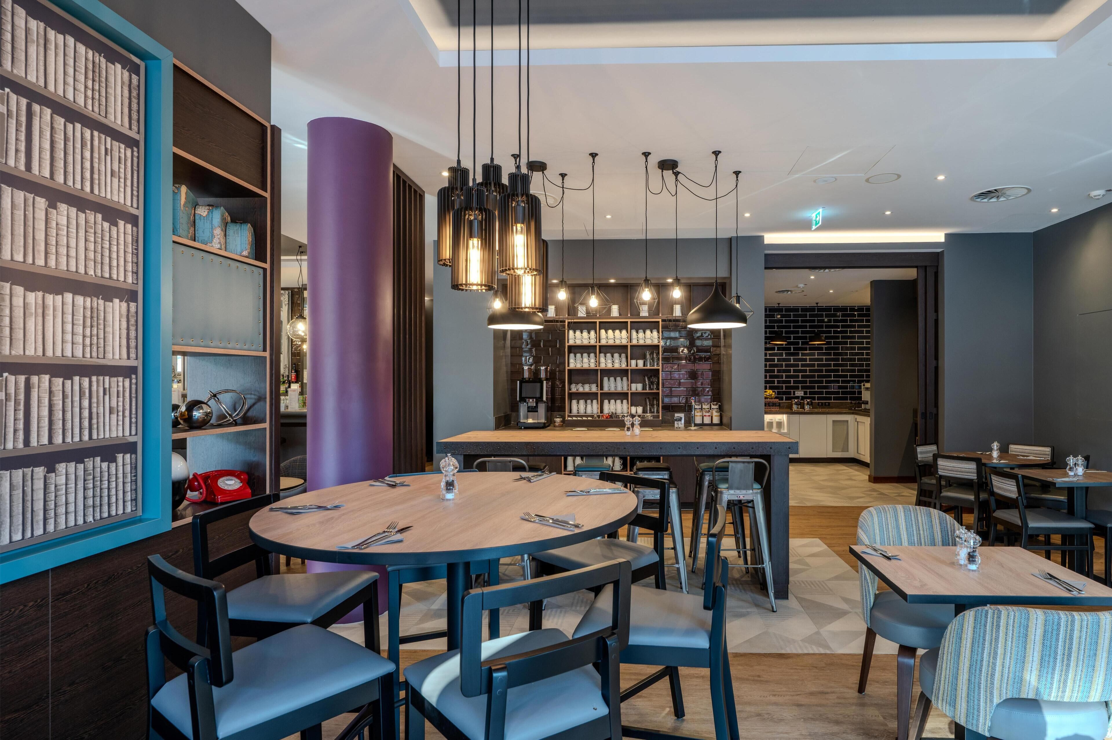 A modern dining area with round tables, chairs, and a central bar.