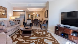 A modern living room with a sofa, coffee table, and TV stand. - Ocean View 3BR Condo – Unit 208 Royale Palms (Myrtle Beach)