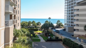 A residential building with balconies overlooking a street and a beach. - Ocean View 3BR Condo – Unit 208 Royale Palms (Myrtle Beach)