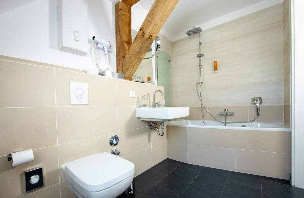 Un baño moderno con inodoro, lavamanos y bañera.