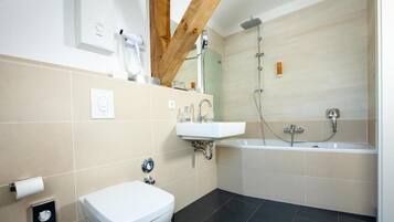 Un baño moderno con inodoro, lavamanos y bañera.