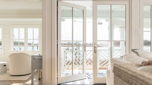 Et værelse med en skydedør, der fører ud til en balkon med udsigt over en bro og vand.