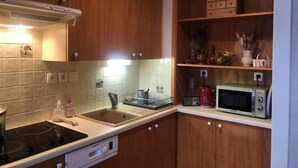 Una cucina con mobili in legno, un forno a microonde, un tostapane e un lavandino.