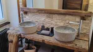 A rustic bathroom with two stone sinks, a wooden vanity, and a large mirror. - Le Loft Des Arts (Thonon-les-Bains)
