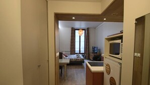 Una habitación de hotel con cama, escritorio, televisor y microondas.