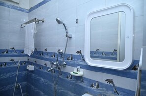 A bathroom with blue and white tiles, a shower with a handheld showerhead, a towel rack, and a small mirror. - Hotel Home Inn Bodhgaya (Bodh Gaya)