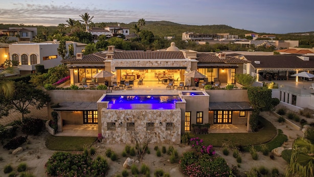 Une villa de luxe dotée d’une piscine, d’un espace repas extérieur et d’un jardin bien entretenu.