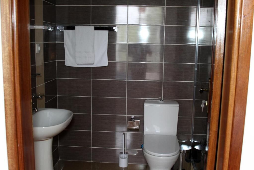 A bathroom with a white sink, a toilet, and a towel rack.