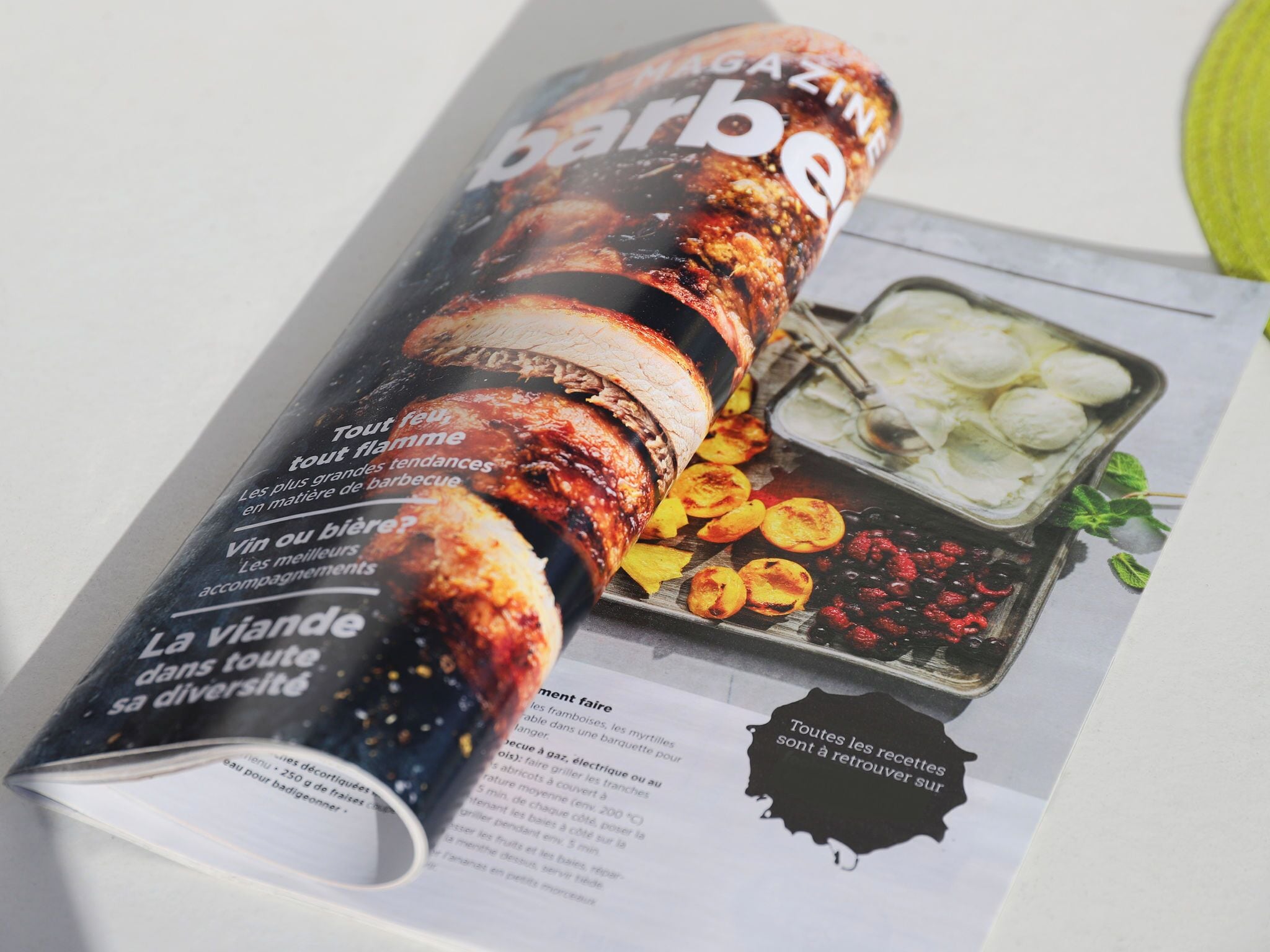Une double page d’un magazine présentant une recette de barbecue avec de la viande et des légumes grillés.