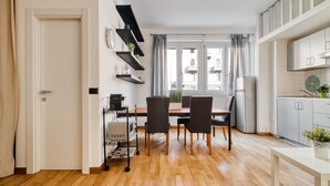 Eine moderne Küche mit Esstisch, Stühlen und einem fenster mit Vorhängen.