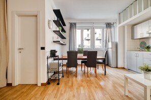Eine moderne Küche mit Esstisch, Stühlen und einem fenster mit Vorhängen.