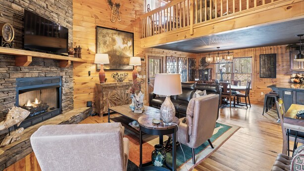A spacious living room with a fireplace, a television, and a dining area. - Welcome to Pine and Buck Lodge, a perfect 3 bedroom 2.5 bathroom get away (Ellijay)