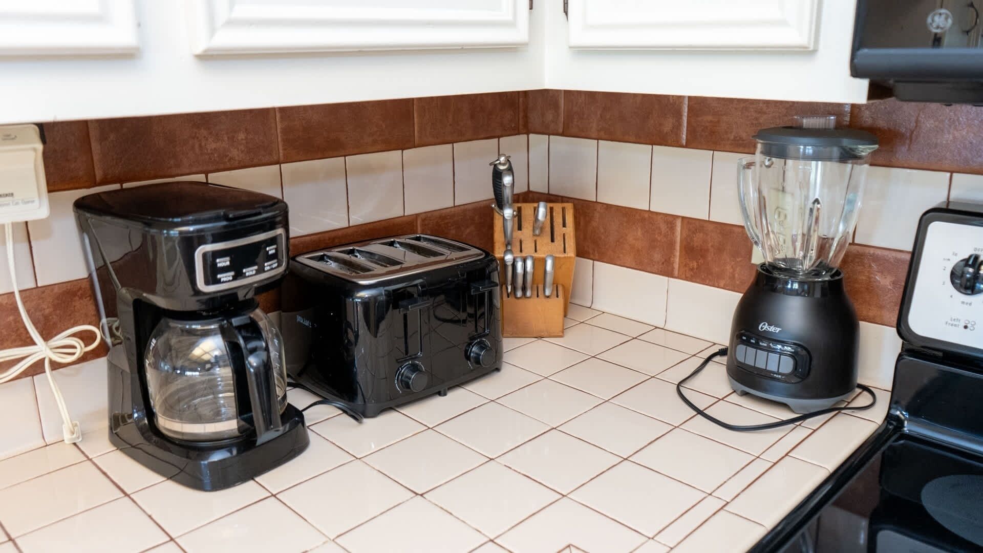 Una cucina con macchina da caffè, tostapane e frullatore sul piano di lavoro.