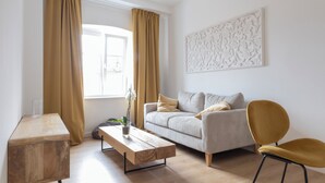 Un salon moderne avec un canapé, une table basse en bois et un fauteuil jaune.