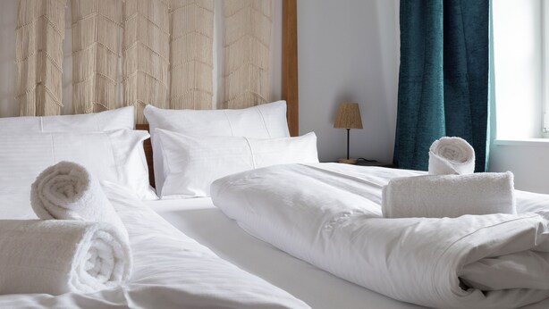Une chambre d’hôtel avec un lit, des oreillers et des serviettes.