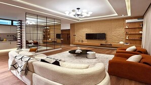 Ein modernes Wohnzimmer mit einer Sofagarnitur, einem Couchtisch und einem an einer strukturierten Wand befestigten Fernseher.