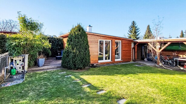 Una casa in legno con un prato curato e un garage.