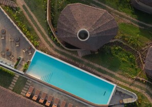 An aerial view of a resort with a swimming pool, lounge area, and a distinctive thatched-roof structure. - Atalaya Restort El Nido (El Nido)