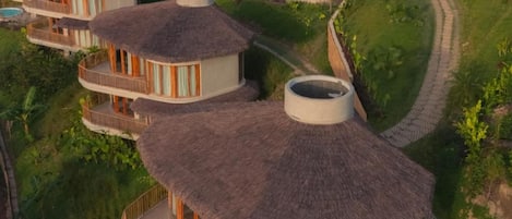 Un resort con varias edificaciones de techos de paja y balcones.