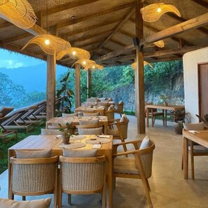 An outdoor dining area with wicker furniture and hanging lights. - Atalaya Restort El Nido (El Nido)